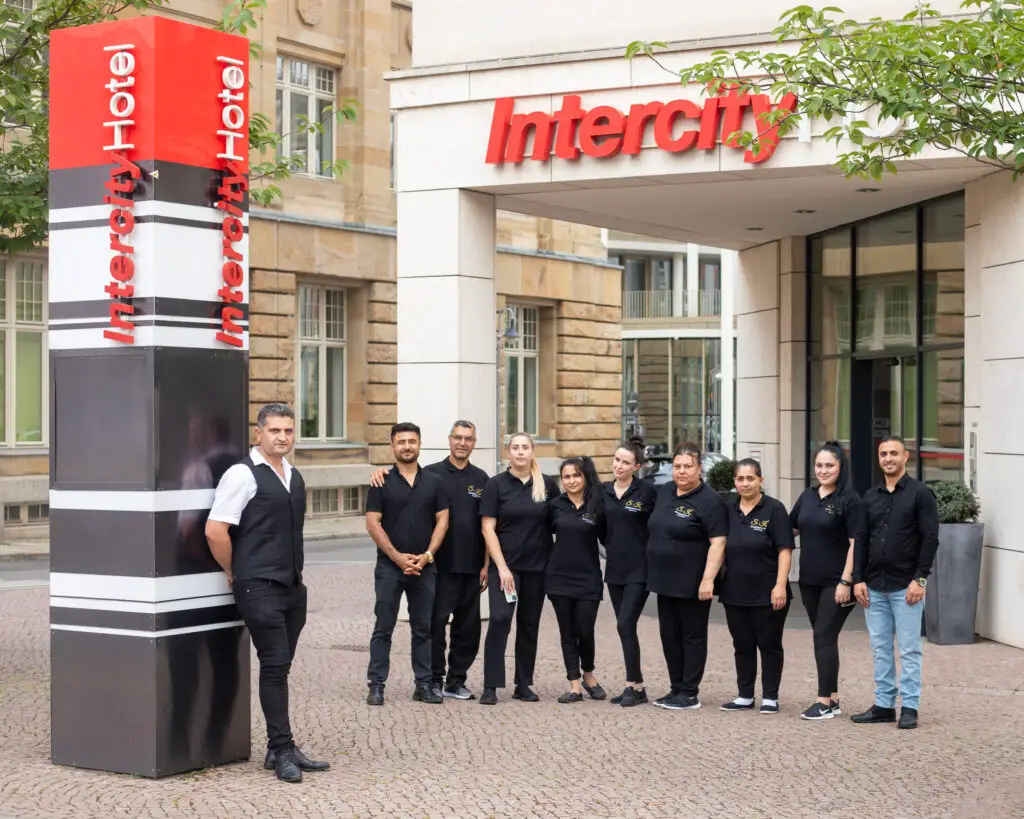 Das Team von S.K. Reinigungsservice Leipzig e.K. steht bereit vor dem Intercity Hotel, um erstklassigen Service zu bieten.